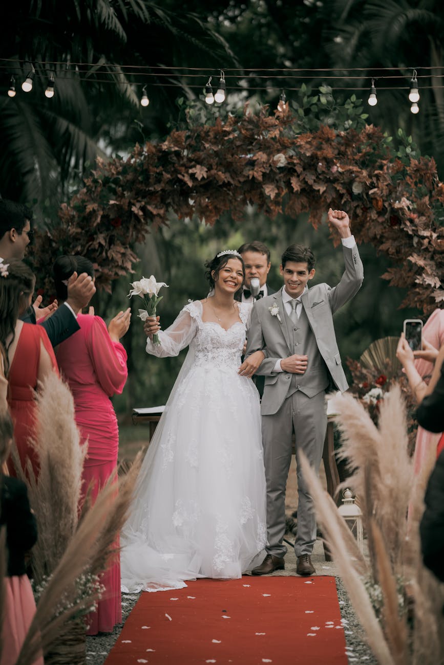 joyful outdoor wedding ceremony under floral arch